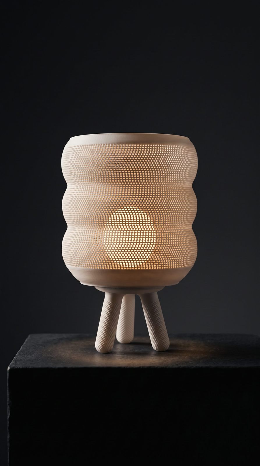 RIDGE lamp glowing on a dark pedestal